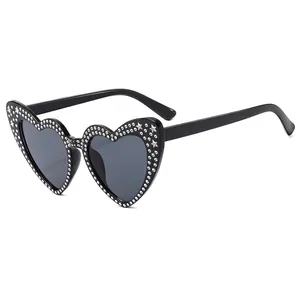 Sparkly heart shaped sunglasses with rhinestones and star studs on black frames
