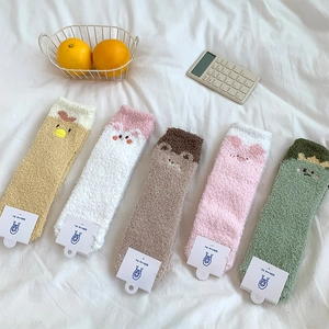 Close-up of five pairs of thick coral fleece socks with cute cartoon animal faces