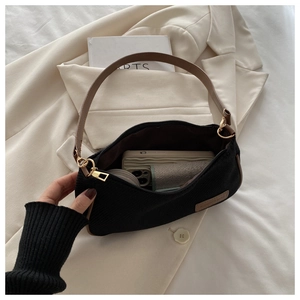Detail view of black moon bag showing internal capacity with phone and wallet inside