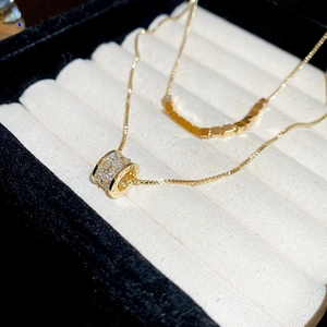 Macro shot of 18k gold plated double layer necklace with cubic zirconia cylinder pendant