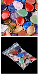 Macro shot of assorted teardrop-shaped natural stone pendants in bulk and packaged