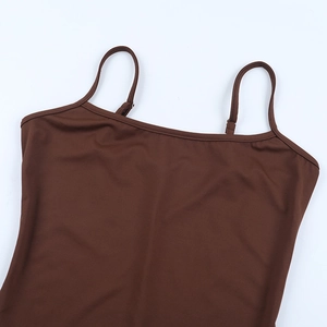 Détail des fines bretelles réglables sur une robe marron en tulle à découpes