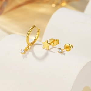 Macro detail of three-piece gold S925 stud earring set with star and zircon inlay