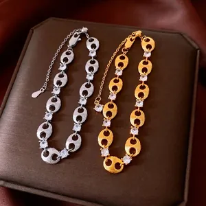 Gold and silver pig nose chain bracelet with zircon stones on silk jewelry box