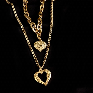Dubbellaagse gouden titanium stalen ketting met hartjes hangers op zwarte zijden textuur