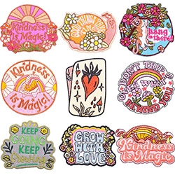 Detail view of 9 vintage embroidered patches with floral and inspirational slogans