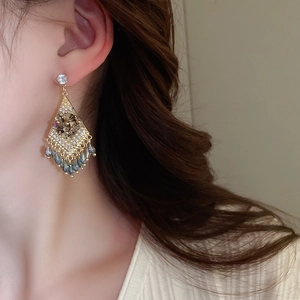 Detail of diamond rhombus earrings with blue-grey teardrop crystal tassels and pearls