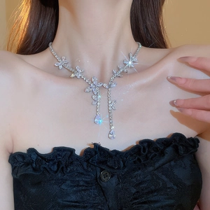 Close-up of elegant silver flower necklace with marquise crystals on a model's neck