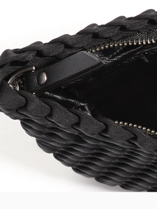 Close-up of metal zipper and leather pull on black woven bubble textured tote bag