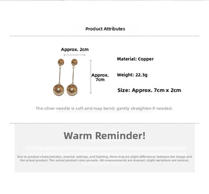 Detail view of long gold metal ball earrings showing 7cm length and silver needle studs