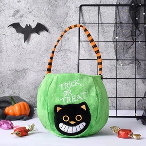 Detail of green plush Halloween candy bag with black cat embroidery and striped handle