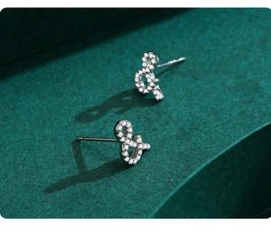 Détail de boucles d'oreilles clous en argent S925 en forme de esperluette avec zircons