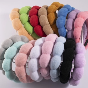 Macro shot of colorful plush sponge headbands organized on a neat metal storage rack