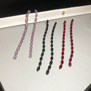 Dettaglio di orecchini a nappa con zirconi a taglio marquise nei colori rosa, nero e rosso