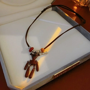 Detailed close-up of brown bear pendant necklace in a velvet jewelry gift box