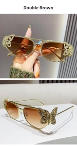 Detail of golden metal frame sunglasses with crystal-encrusted butterfly wings and brown lenses