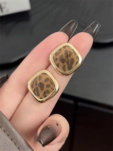 Close-up of vintage square leopard print stud earrings with golden metallic edges