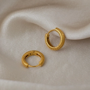 French vintage style striped gold hoop earrings with textured finish on champagne silk