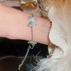 Detailed view of elegant silver butterfly bracelet with sparkling zircon stones on model wrist