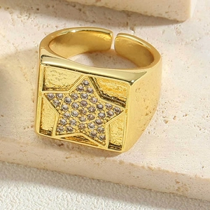 Detailed close-up of 14K gold plated star ring with zircon on stone surface