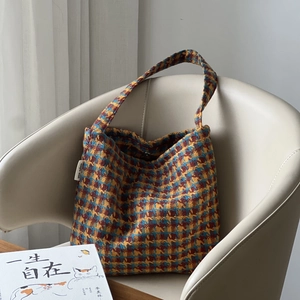 Retro houndstooth knit shoulder bag in blue and yellow on a cream leather chair