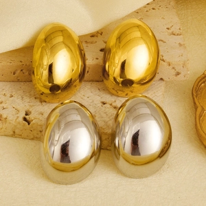 Macro shot of 304 stainless steel drop earrings in gold and silver on stone