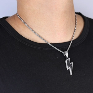 Gros plan du pendentif éclair hip hop avec zircons incrustés porté par un mannequin