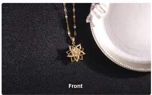 Macro view of rotating clover pendant with cubic zirconia on gold wave chain