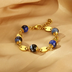 Macro shot of gold stainless steel bracelet with textured blue and black resin beads