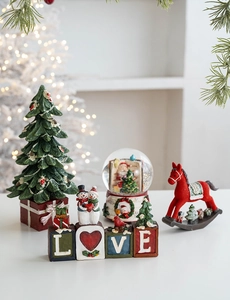 Close-up of resin Santa rocking horse and LOVE snowman blocks for festive home decor