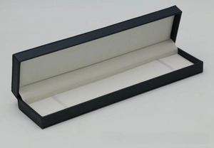 Detail of navy blue PU leather jewelry box with cream interior and elastic security straps