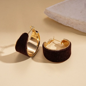 Detail of dark brown flocked geometric hoop earrings with polished gold metal lining