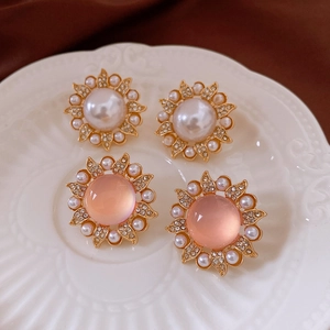 Détail de boucles d'oreilles vintage tournesol avec perles et cristaux sur une assiette