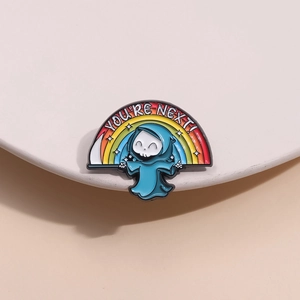 Rainbow reaper enamel pin with You're Next text on a sleek white display stand
