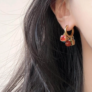 Ethnic style gold hoop earrings with zircon and agate charms on female model