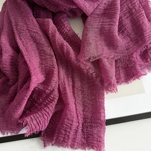 Detail of fuchsia linen scarf showing crinkle texture and fringe raw edge finish