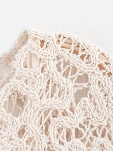 Gros plan détaillé sur la texture complexe du crochet ivoire et les motifs ajourés