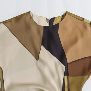 Detailed close-up of geometric print satin blouse featuring round neck and button closure