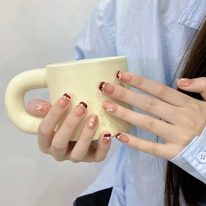 Handgefertigte rote Kunstnägel mit eleganten Perlen und 3D-Schmetterling-Dekor