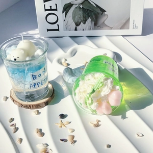Detail of creative summer drink candles with polar bear and flower decors in glass cups