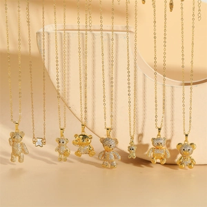Golden bear pendant necklaces with cubic zirconia in assorted styles on artistic display