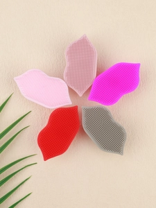 Detailed view of colorful silicone lip exfoliating brushes with suction cups on sand