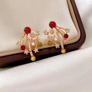 Detail of floral tassel earrings with red beads and teardrop crystals in a jewelry box