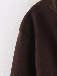 Macro shot of dark brown wool coat shoulder seam detailing high quality texture