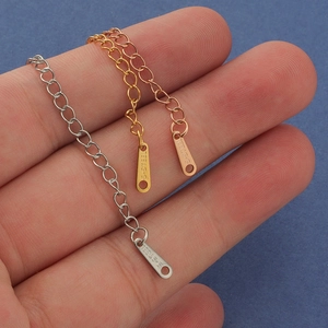 Macro shot of stainless steel extension chains in silver, gold, and rose gold with S-STEEL tags