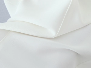 Close-up of white lace fabric texture and detailed stitching on the square neck mini dress