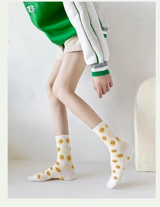 Close-up of white cotton socks featuring a yellow smiley face pattern on the side