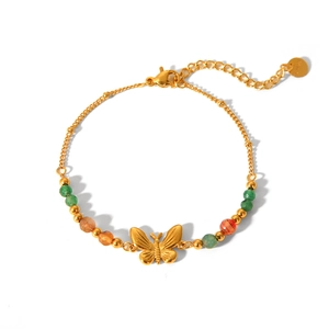 Detailed view of golden butterfly pendant and colorful beads on stainless steel bracelet