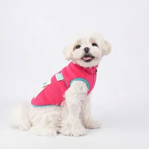 Rose pink fleece pet vest with blue trim and pocket for small dogs on a white dog