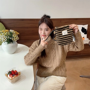 Detail of plush brown striped drawstring bag with sozakka beaute label on cozy knit